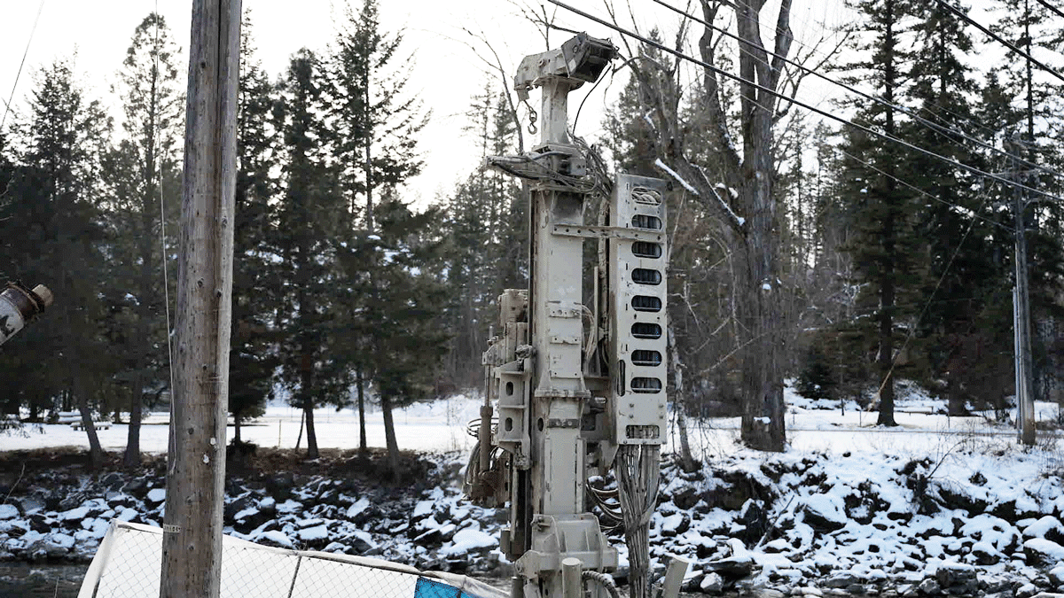 Comacchio MC 14 fully articulated microdrilling rig mast and carriage in front of a snowy riverbank and trees on a cold‑weather foundation project.