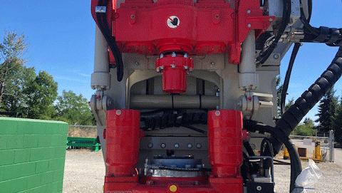 Comacchio MC 15P fully articulated multipurpose drill rig close‑up of bright red Eurodrill rotary head and clamp system on the mast in a gravel yard.