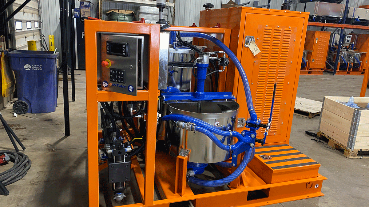 Intric D-12 high shear colloidal grout plant in warehouse, showing stainless steel mixing tank, storage tank, and diesel power pack on skid frame