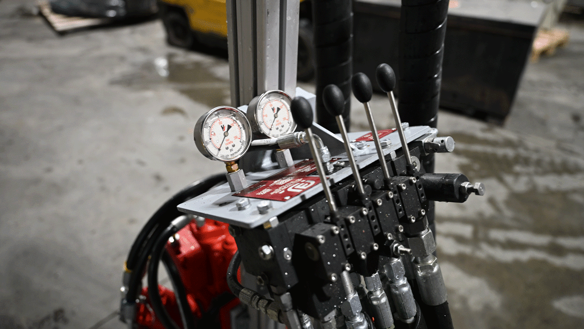 Close-up of American-made TEI MP260 man-portable drilling system hydraulic control panel with pressure gauges and manual control levers for precise limited-access drilling adjustments