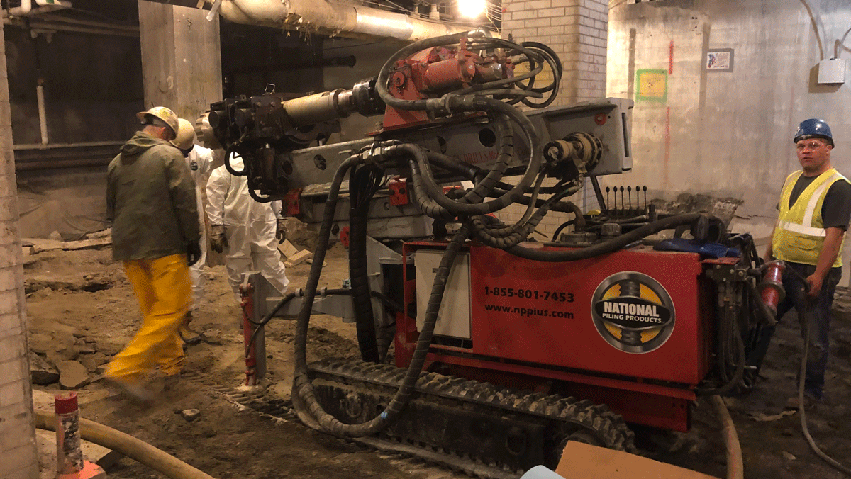 “TEI TD‑75 electric‑hydraulic limited‑access drill rig installing micropiles inside an existing building with National Piling Products crew.”