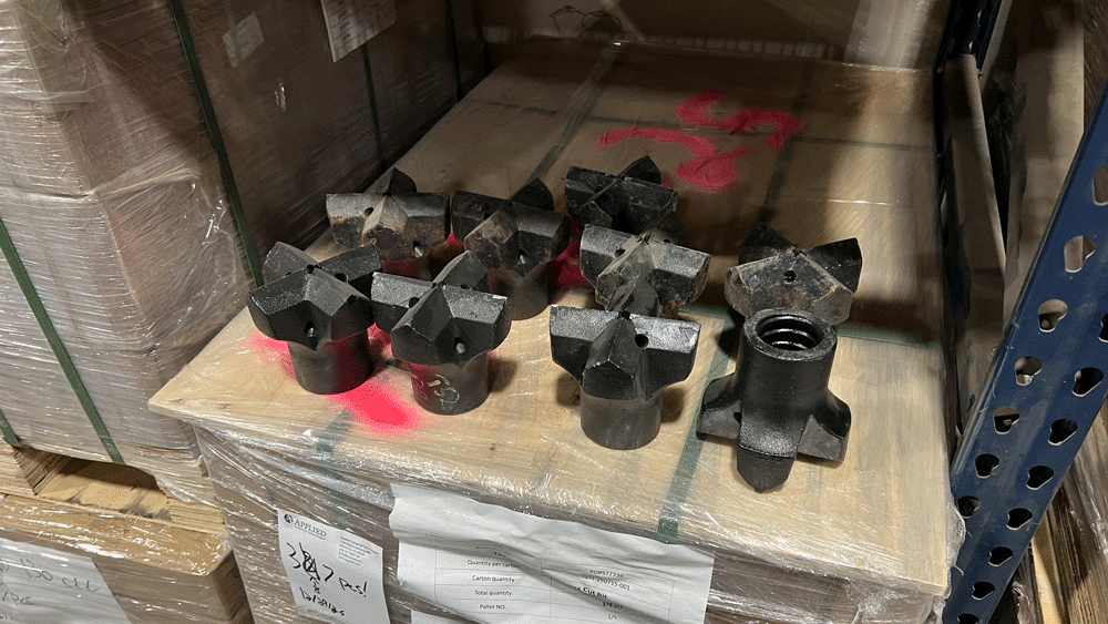 Hollow bar drill bits displayed on a pallet in the National Piling Products warehouse.