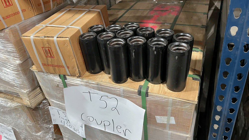 Hollow bar couplers arranged on top of boxed inventory in the National Piling Products warehouse.