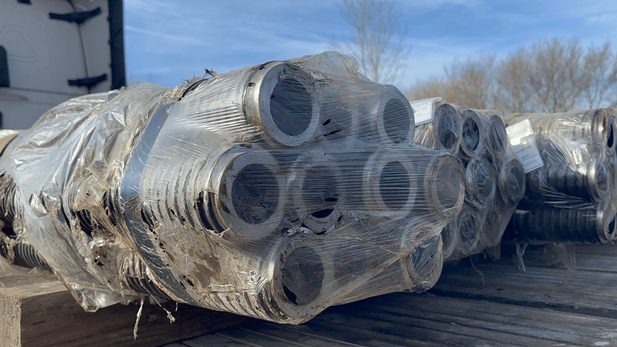 Wrapped bundle of hollow bar micropile pipe sections on a flatbed truck at National Piling Products.